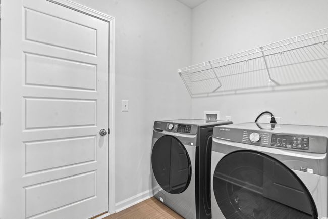Washroom with washer and clothes dryer and light wood-style flooring | Image 9