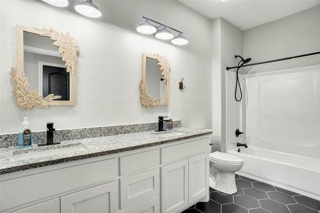 Full bathroom with toilet, tile floors, dual vanity, and bathing tub / shower combination | Image 30