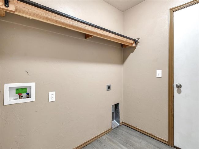 Laundry area featuring hookup for an electric dryer, laundry area, hookup for a washing machine, light wood-style flooring, and baseboards | Image 17