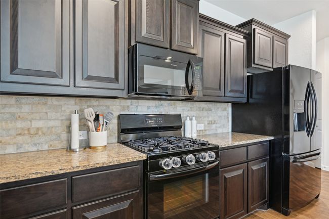 Kitchen featuring black appliances and dark brown cabinetry | Image 11