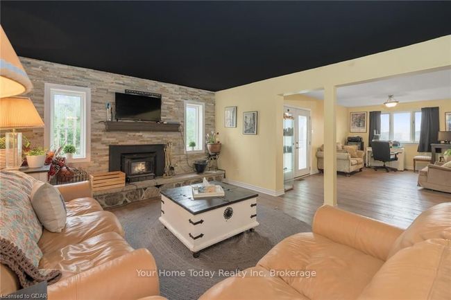 Living room featuring plenty of natural light, ceiling fan, dark hardwood / wood-style flooring, and a fireplace | Image 19