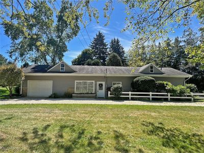 Ranch-style home featuring a garage and a front lawn | Image 1