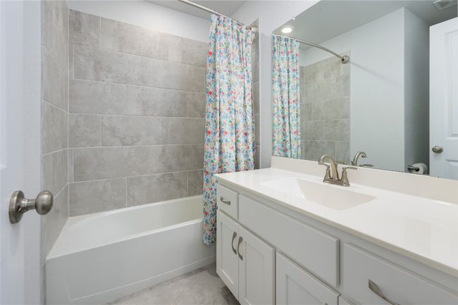 Full bath featuring vanity, shower / bath combo with shower curtain, and tile patterned floors | Image 24