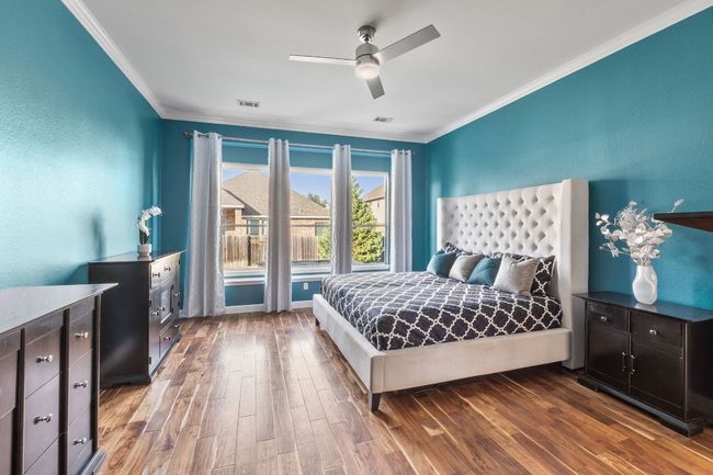 Large master bedroom features crown molding and hardwood floors. | Image 10
