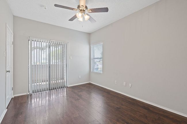 Empty room featuring baseboards, ceiling fan, a textured ceiling, and wood finished floors | Image 13