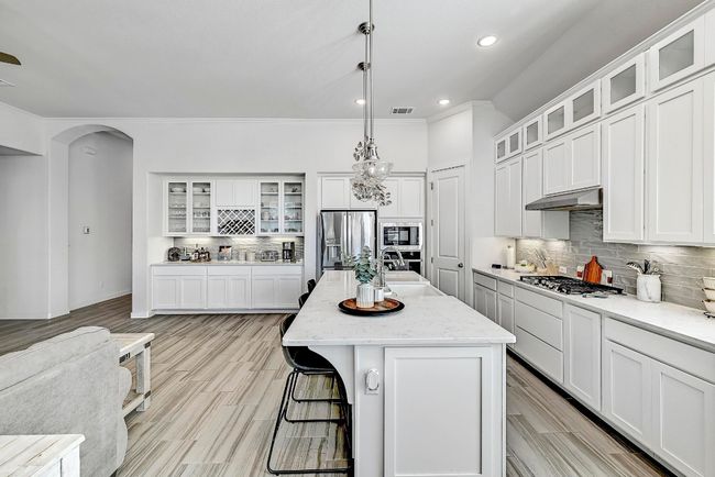 Premium stainless-steel appliances, quartz countertops, and white cabinetry make this kitchen as functional as it is beautiful. | Image 8