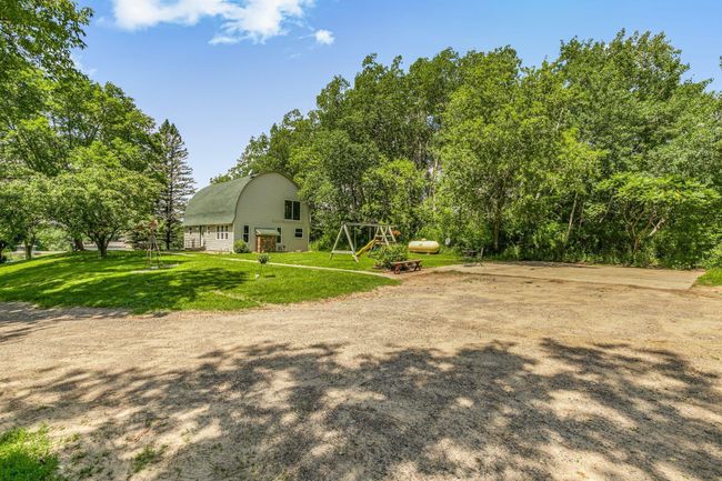 Driveway wraps around to the back side of the home with concrete slab for additional parking + main level entry | Image 30