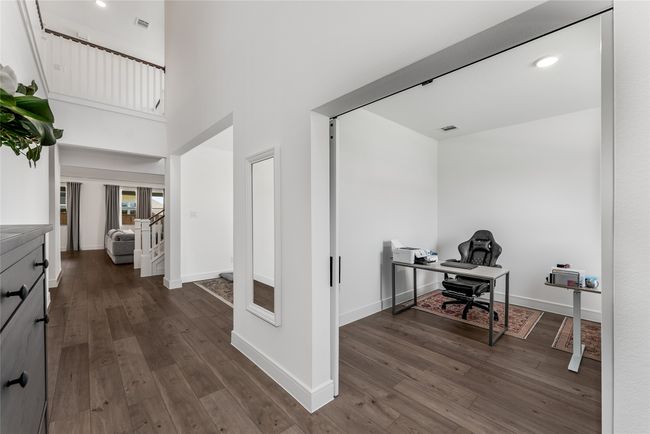 Office area featuring dark wood-style flooring and a towering ceiling | Image 14