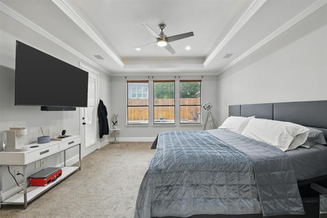Primary bedroom on the first level offers lots of space and views of the beautiful backyard and pool. | Image 17