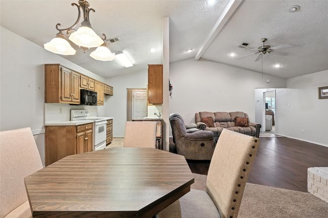 Dining area featuring a ceiling fan, a textured ceiling, wood finished floors, and recessed lighting | Image 21
