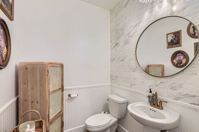 Half bath with a wainscoted wall and tile walls | Image 13