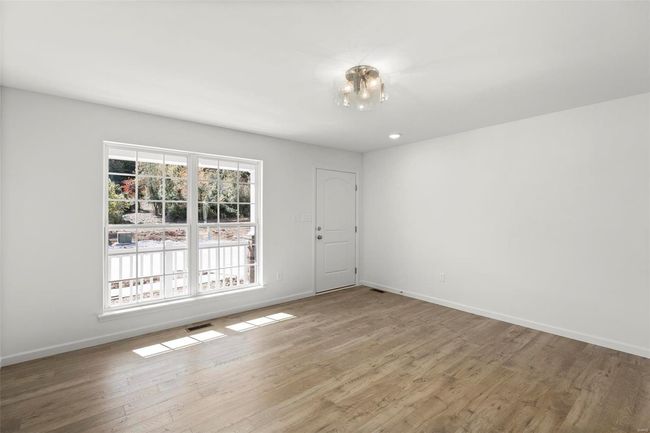 Empty room with a notable chandelier and wood-type flooring | Image 21