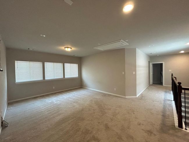 Empty room with attic access, light carpet, baseboards, and recessed lighting | Image 23
