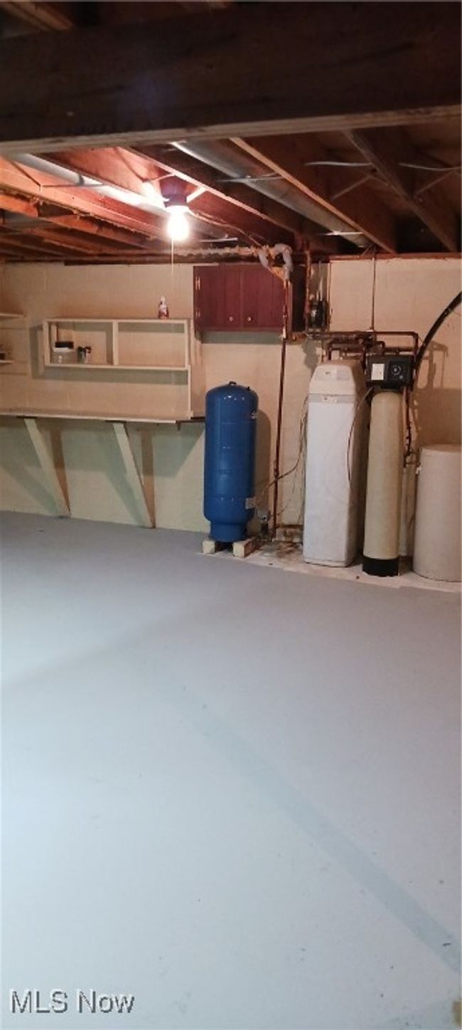 Unfinished basement with a water pressure tank and a water softener system | Image 32