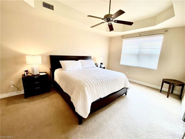 Bedroom with visible vents, a ceiling fan, baseboards, and light carpet | Image 9