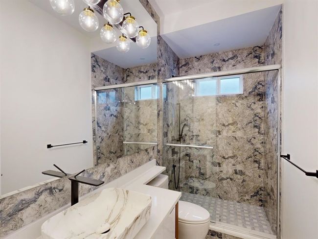 Full bathroom with vanity, a chandelier, and a shower stall | Image 20