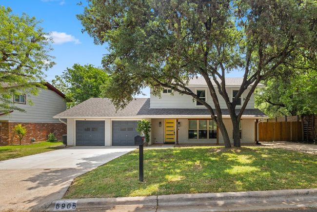 View of front of property featuring fence, a front lawn, concrete driveway, brick siding, and a garage | Image 5
