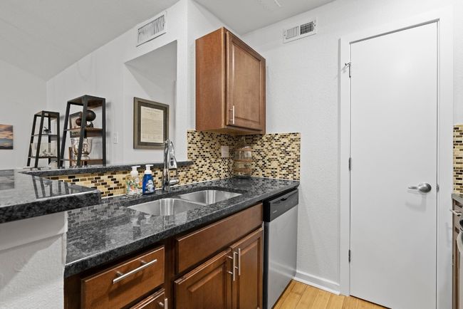 Kitchen with a sink, dishwasher, light wood-style flooring, and decorative backsplash | Image 16