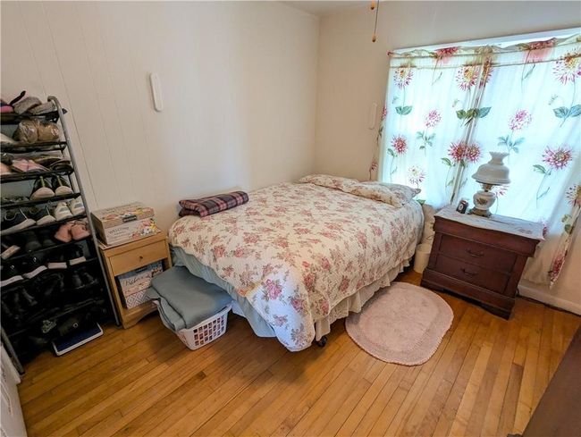 Bedroom with light wood-type flooring | Image 23