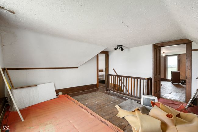 bonus room with a textured ceiling, hardwood / wood-style flooring, and lofted ceiling | Image 11