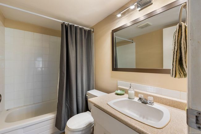 Full bathroom with toilet, shower / bath combo with shower curtain, and vanity | Image 21