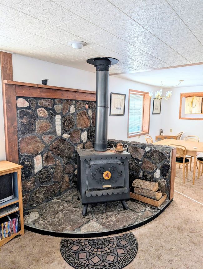 Interior details featuring carpet and a wood stove | Image 7