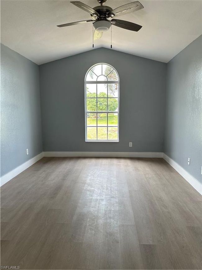 Empty room featuring lofted ceiling, wood finished floors, and a ceiling fan | Image 15