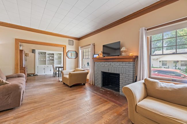 Living area featuring ornamental molding, a brick fireplace, and light wood finished floors | Image 22