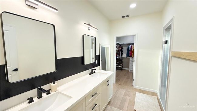 Full bathroom featuring double vanity, wood finished floors, and a spacious closet | Image 14