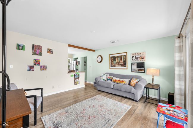 living area with baseboards, wood finished floors, and visible vents | Image 13