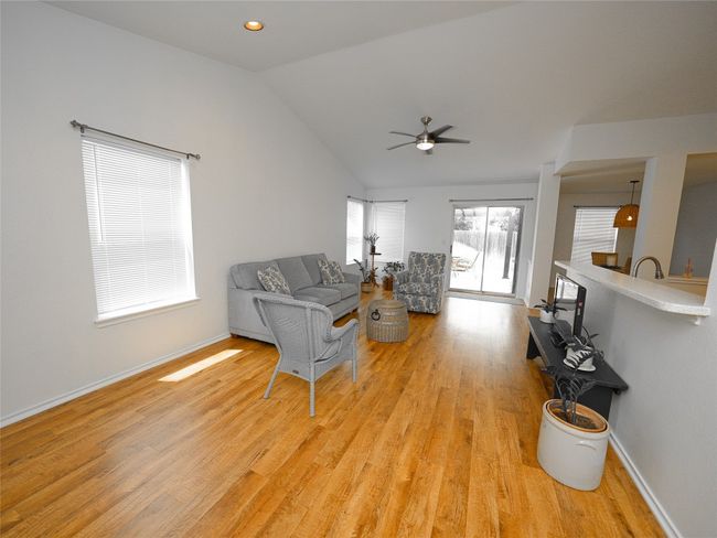 Living room featuring light wood-style floors, baseboards, ceiling fan, and vaulted ceiling | Image 16