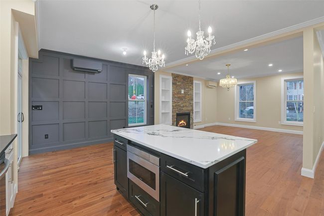 Kitchen island allows for extra workspace and storage, accented with pendant lighting. | Image 14