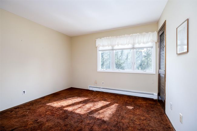 Empty room featuring carpet flooring and a baseboard radiator | Image 25