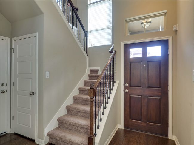 Stairs with iron balusters leading to game room and bedrooms upsatirs. | Image 17