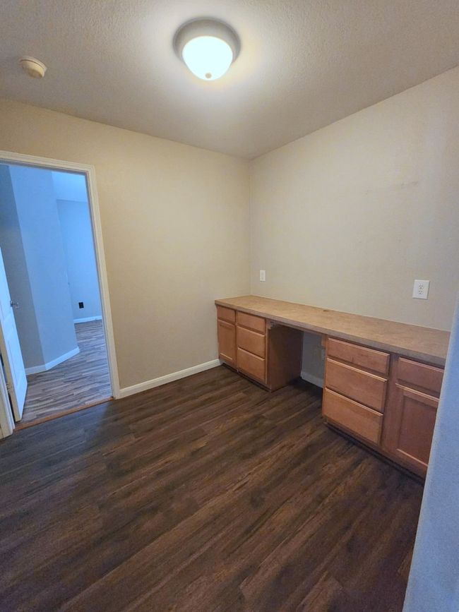 Spare room featuring a ceiling fan, dark wood finished floors, lofted ceiling, and baseboards | Image 14