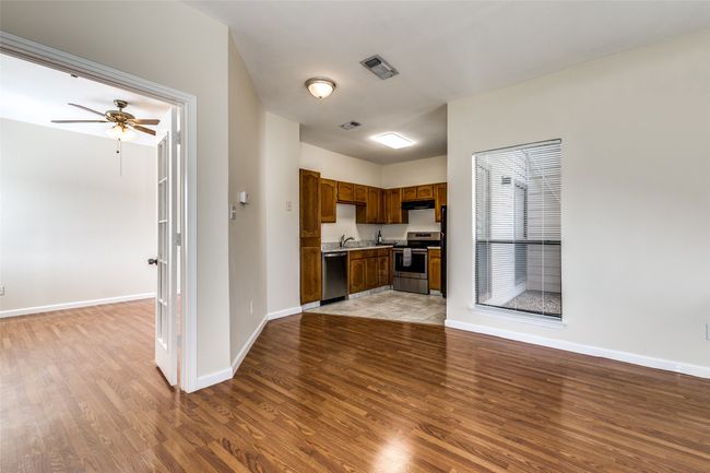 Kitchen with visible vents, light wood finished floors, baseboards, appliances with stainless steel finishes, and under cabinet range hood | Image 8
