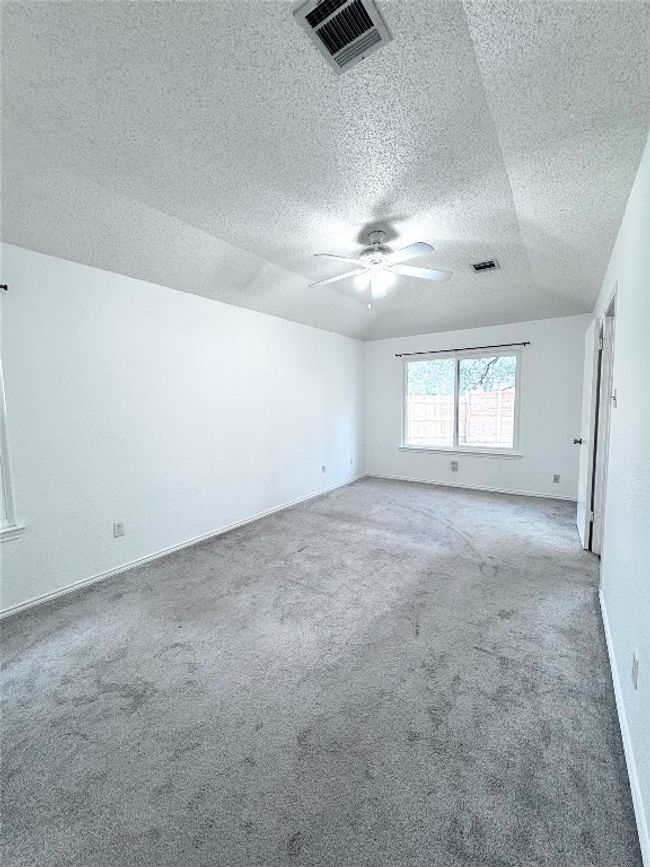Carpeted empty room with a textured ceiling and baseboards | Image 15