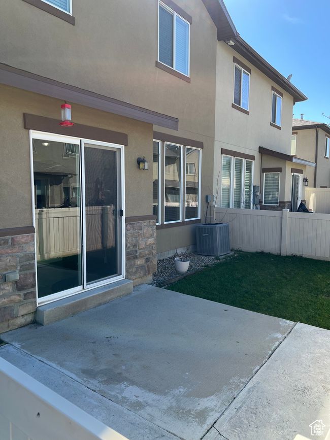 Rear view of property with stucco siding, fence, a patio area, and central air condition unit | Image 5