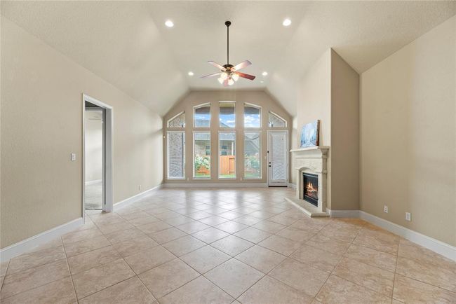 The family room has a cozy gas log fireplace. | Image 13