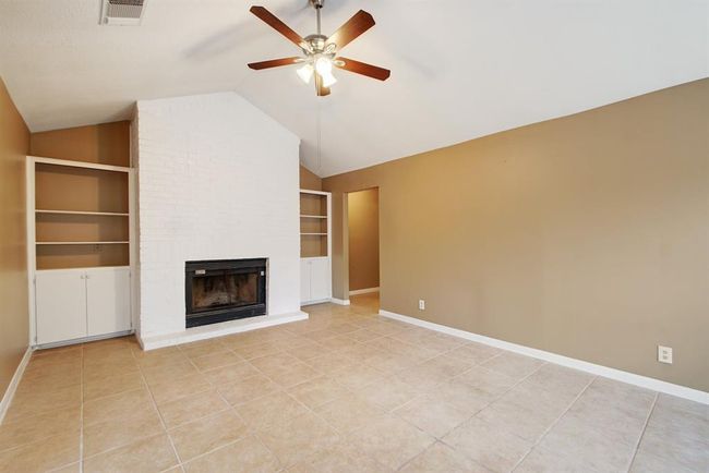 The living room has cathedral ceilings | Image 5
