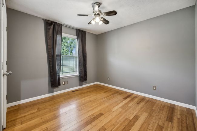 This lovely secondary bedroom is equipped with its own ceiling fan, neutral color palette, and beautiful bamboo flooring! 2095 Bolden Drive, Murfreesboro, TN 37127 | Image 18