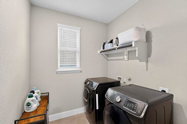 Laundry area featuring separate washer and dryer and light tile patterned floors | Image 12