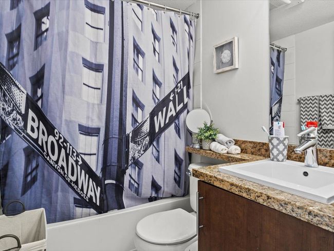 Bathroom featuring vanity, shower / bath combination with curtain, and a textured ceiling | Image 13