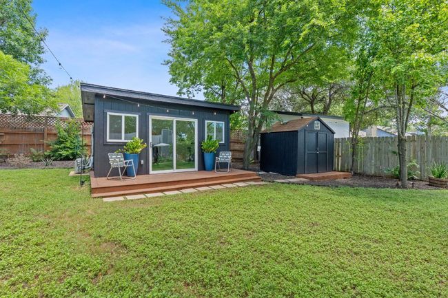 Back of property with a wooden deck, a fenced backyard, and a storage unit | Image 36