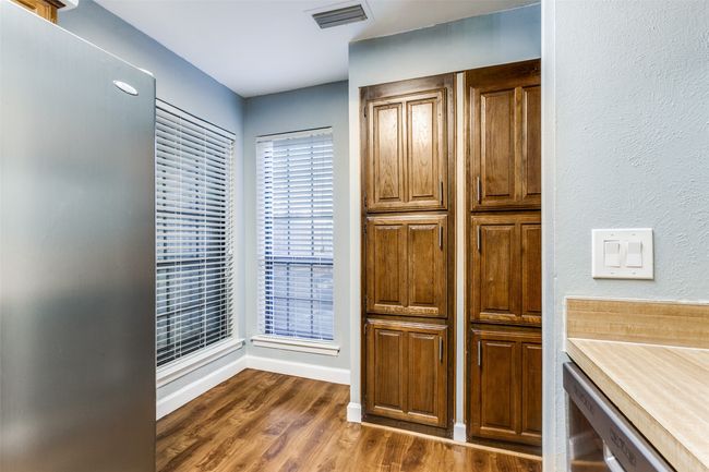 Kitchen with dark wood finished floors, freestanding refrigerator, and light countertops | Image 19
