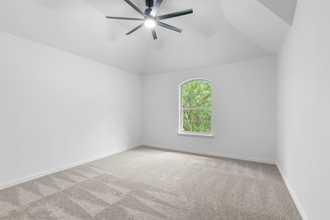 Carpeted spare room featuring lofted ceiling, a ceiling fan, and baseboards | Image 32
