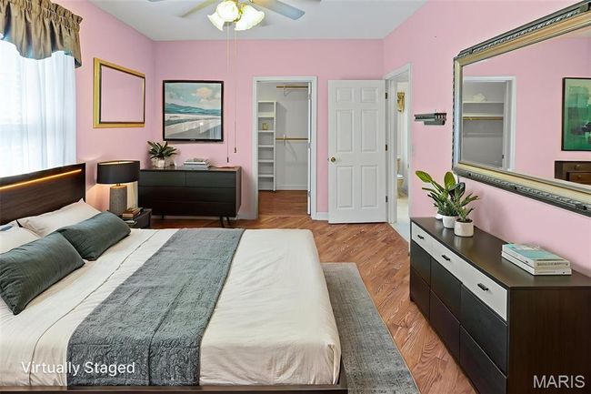 Bedroom with a spacious closet, light wood finished floors, and ceiling fan | Image 30