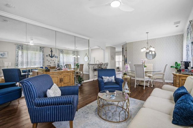 Living area featuring wallpapered walls, ornamental molding, a chandelier, ceiling fan, and baseboards | Image 10