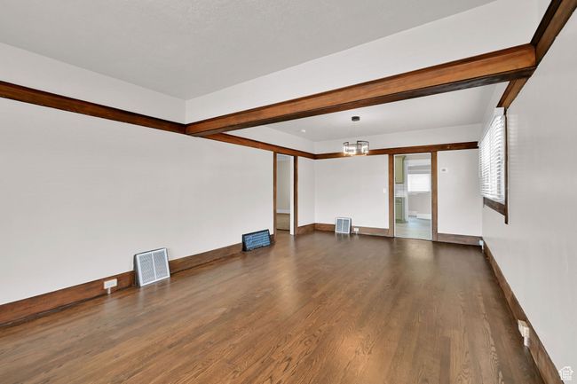 Unfurnished living room featuring dark wood finished floors, baseboards, and a chandelier | Image 5