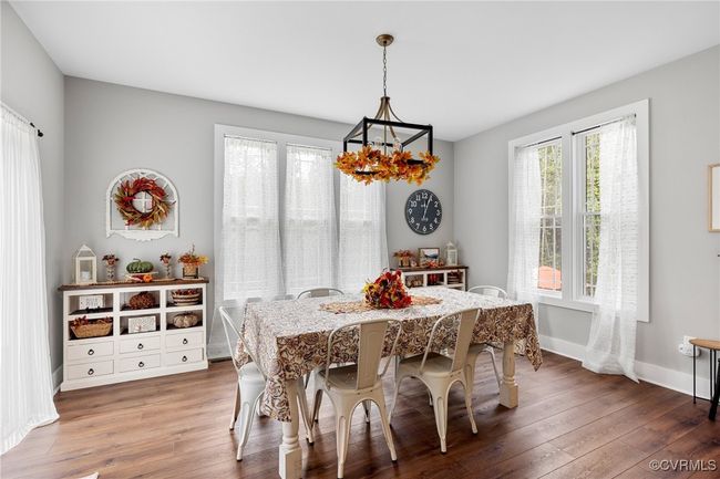 Dining area with baseboards, hardwood / wood-style floors, and a notable chandelier | Image 18